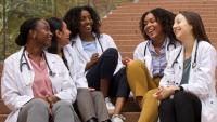 Students in BALSO talking to each other on stairs outside.